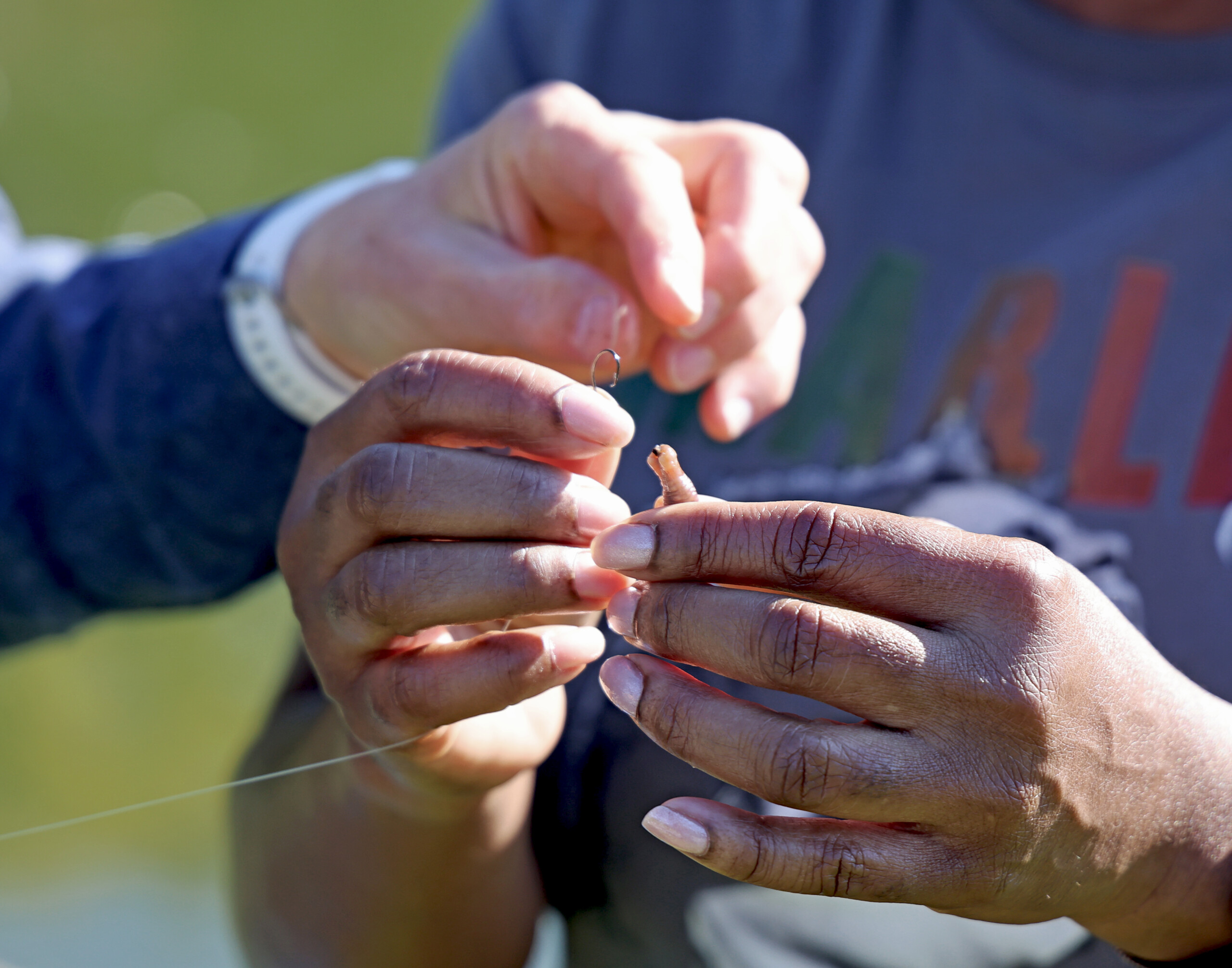 An angler puts a worm on a hook.