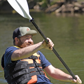 Close-up of man wearing a life jacket and paddling in a kayak along the Conestoga River.