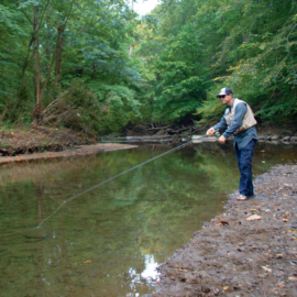 An angler fishes in Philadelphia's Pennypack Creek.