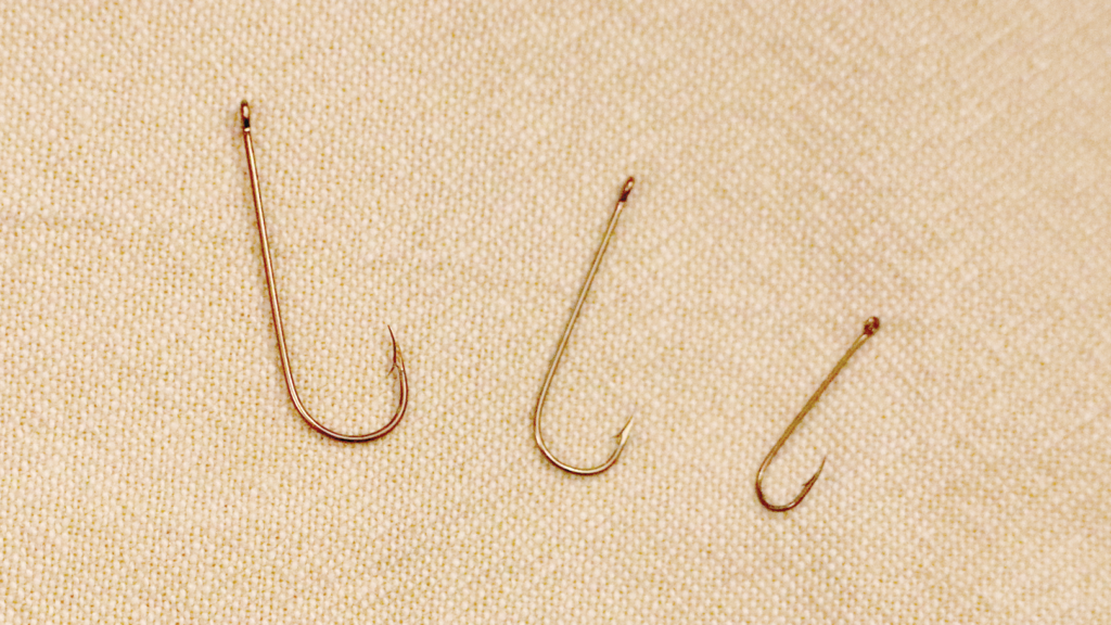 Three different-sized fishing hooks.