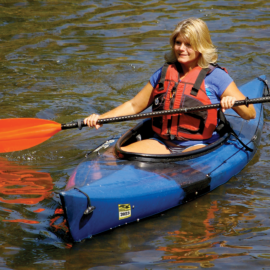 A kayaker paddles on flat water.