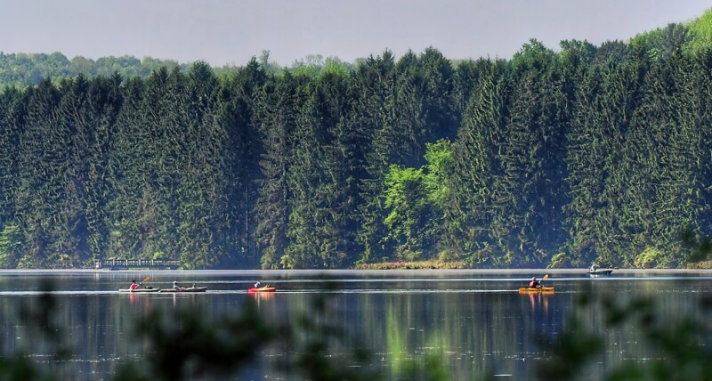 A scenic view of a lake with people paddling