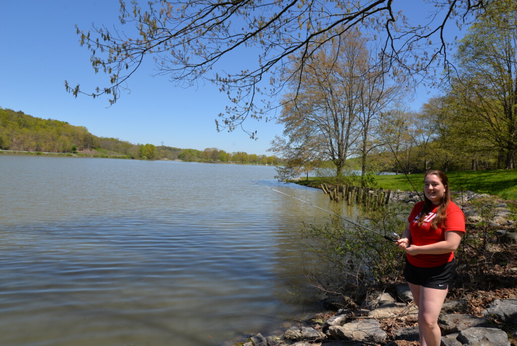 Girl fishing from shore on a lake 